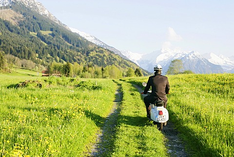 Businessman, 29, on a classic motor scooter, Allgaeu, Bavaria, Germany, Europe