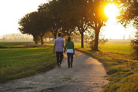 Young couple taking a walk outdoors, in nature