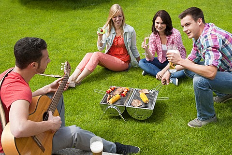 Group of young people having a barbecue in the garden