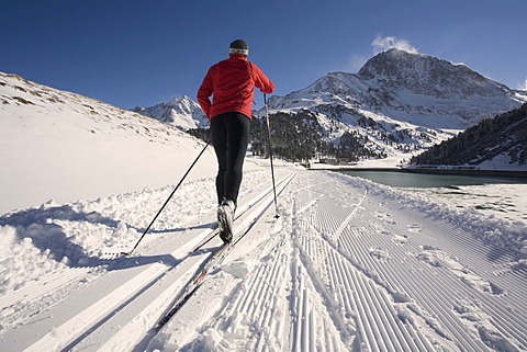 Cross-country skier, right the Laengental Reservoir, Kuehtai, Sellrain Valley, Tyrol, Austria