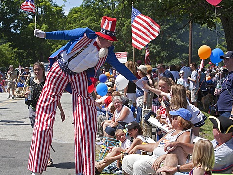 Uncle Sam on stilts greets the crowd at the July 4 parade in a small New England town, Amherst, New Hampshire, USA