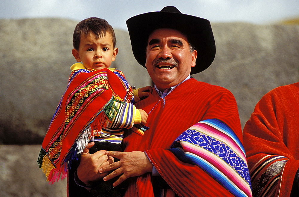 Man with child on his arm . father and son in typical clothes , Suedamerika, Peru, Anden