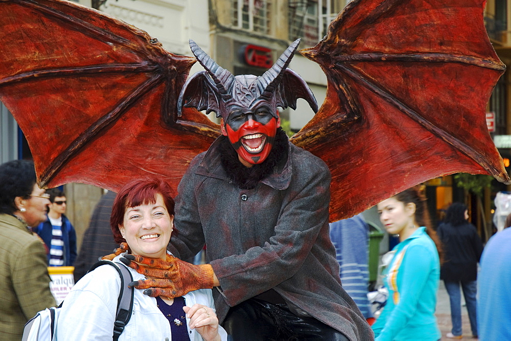 Man wearing a Lucifer costume strangling a smiling woman, crude carnival characters and satirical sculptures at a parade, Fallas festival, Falles festival in Valencia in early spring, Spain, Europe