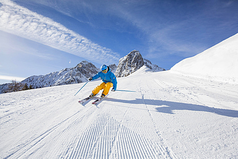 Skier with a helmet skiing down a slope, Mutterer Alm near Innsbruck, Tyrol, Austria, Europe