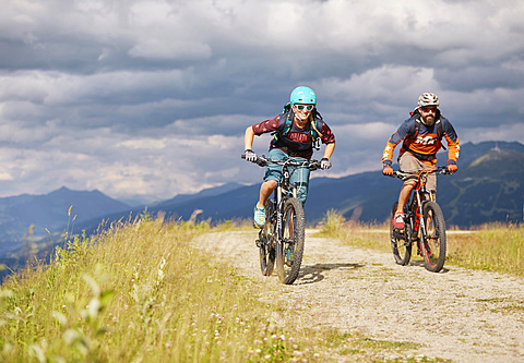 Two mountain bikers with helmets riding on gravel roads, Mutterer Alm near Innsbruck, Patscherkofel, Tyrol, Austria, Europe