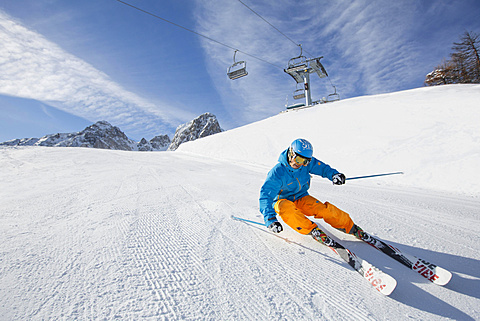 Skier with a helmet skiing down a slope, Mutterer Alm near Innsbruck, Tyrol, Austria, Europe