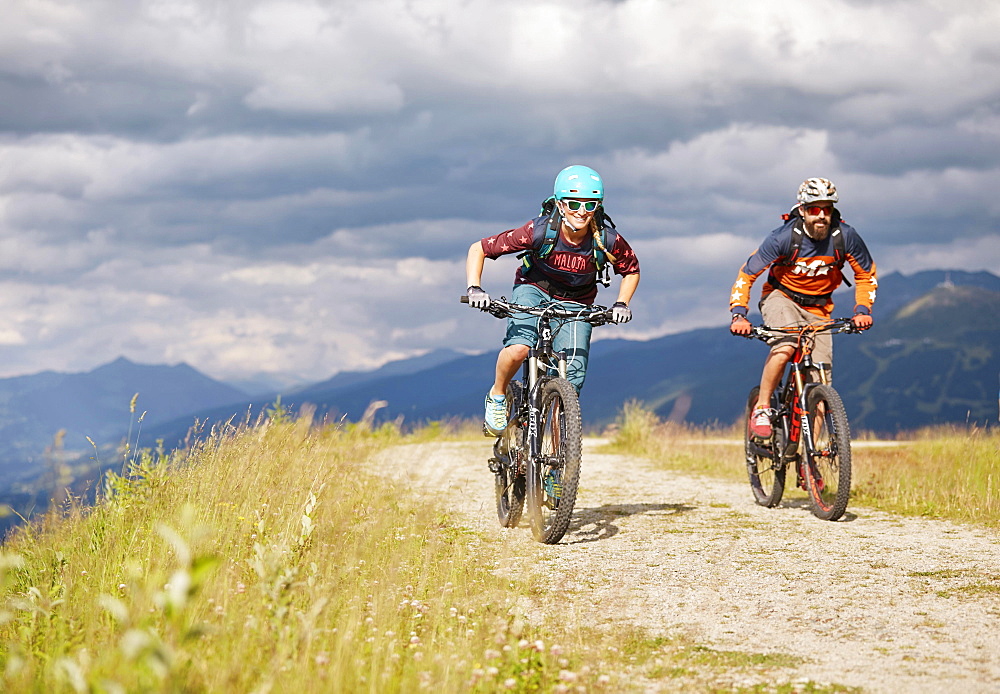 Two mountain bikers with helmets riding on gravel roads, Mutterer Alm near Innsbruck, Patscherkofel, Tyrol, Austria, Europe