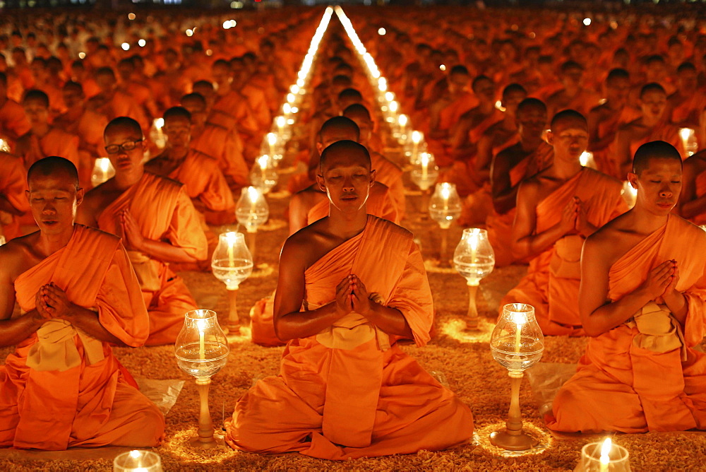 Monks sitting in rows praying and meditating by candlelight, Wat Phra Dhammakaya Temple, Khlong Luang District, Pathum Thani, Bangkok, Thailand, Asia