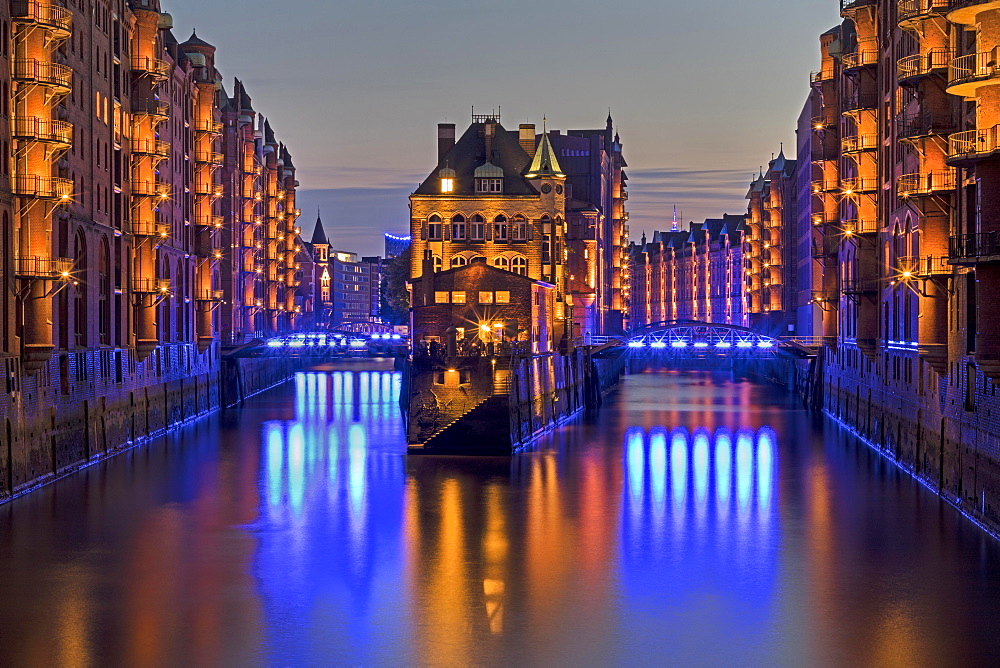 Illuminated ""Wasserschloss"" between Hollandischerbrookfleet and Wandrahmsfleet in the Speicherstadt, evening twilight, Hamburg, Germany, Europe