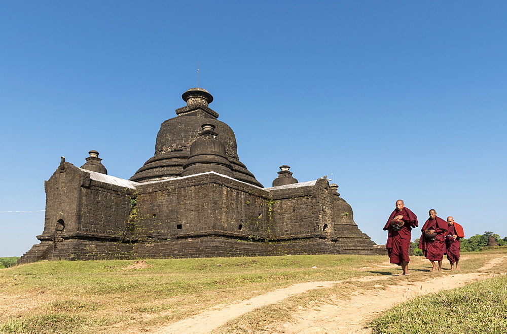 Buddhist monks collect morning alms in front of Laymyetnha Paya, Lemyethna Temple, Mrauk U, Burma, Myanmar, Asia