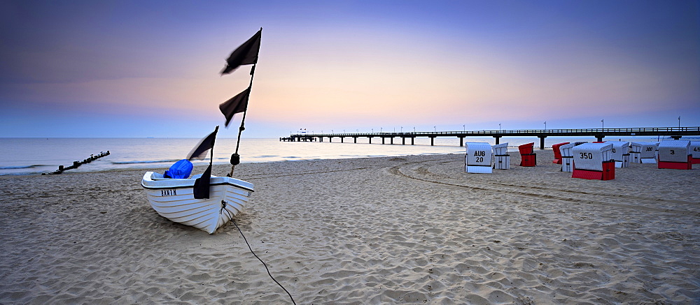 Fishing boat, pier and chairs on beach at sunrise, Baltic resort Bansin, Usedom, Mecklenburg-Western Pomerania, Germany, Europe