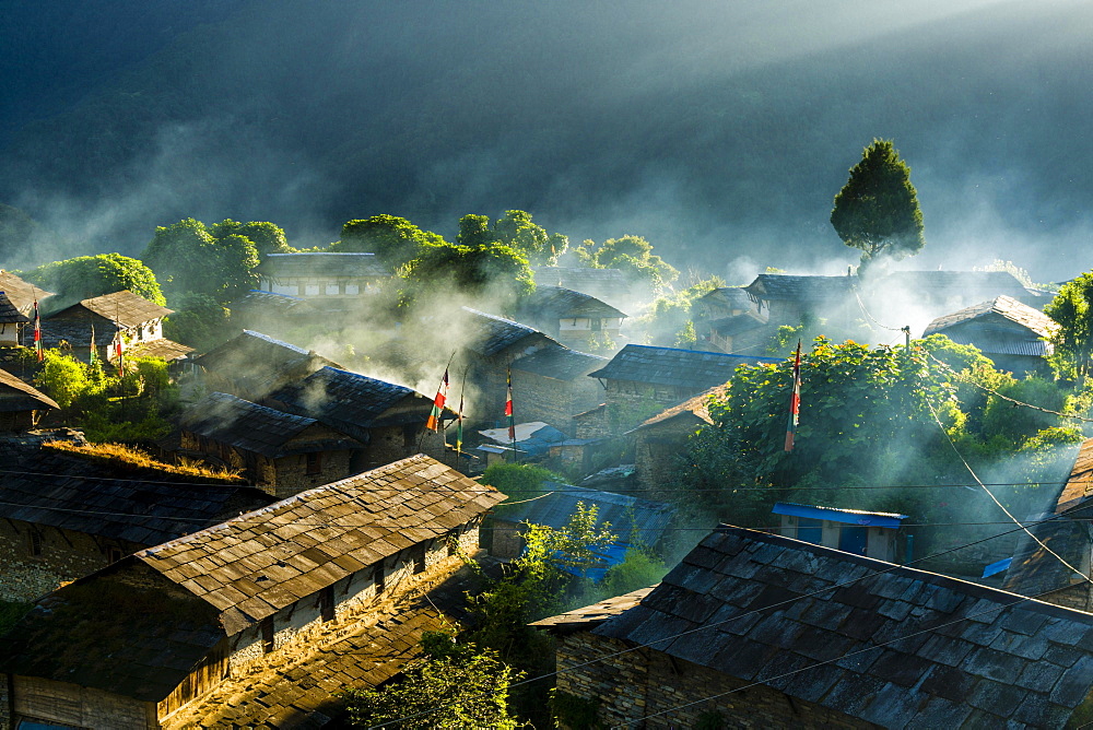 View on village in morning light, smoke is coming out of the houses, Ghandruk, Kaski District, Nepal, Asia