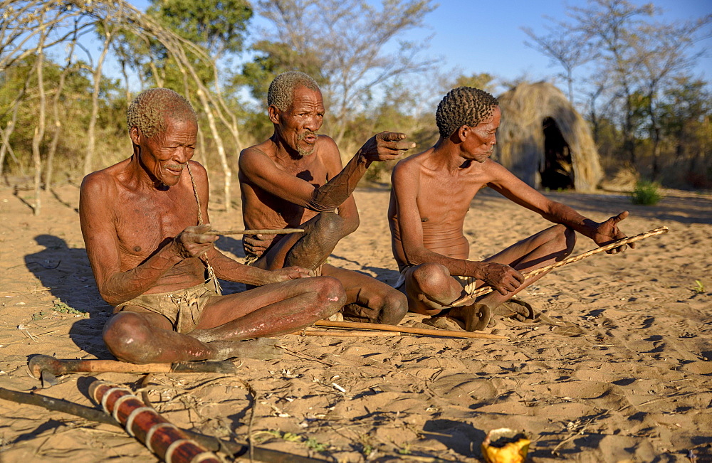 Bushmen of Ju/' Hoansi-San sitting on the ground, village //Xa/oba, near Tsumkwe, Otjozondjupa region, Namibia, Africa