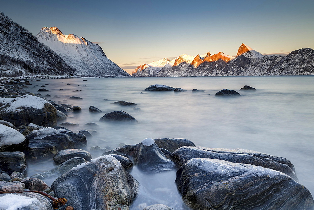 Norwegian fjord, snow-covered mountains at sunset, near Mefjordvær, Senja Island, Norway, Europe