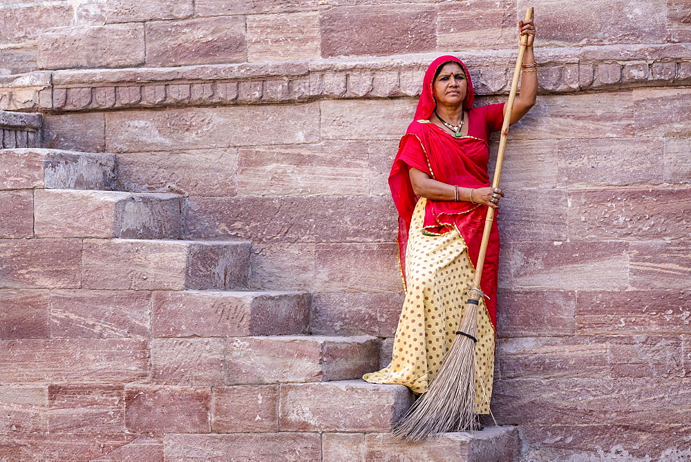 Woman in Sari sweeping steps, resting, Toorji Ka Jhalara, The Step Well, Jodphur, Rajasthan, India, Asia