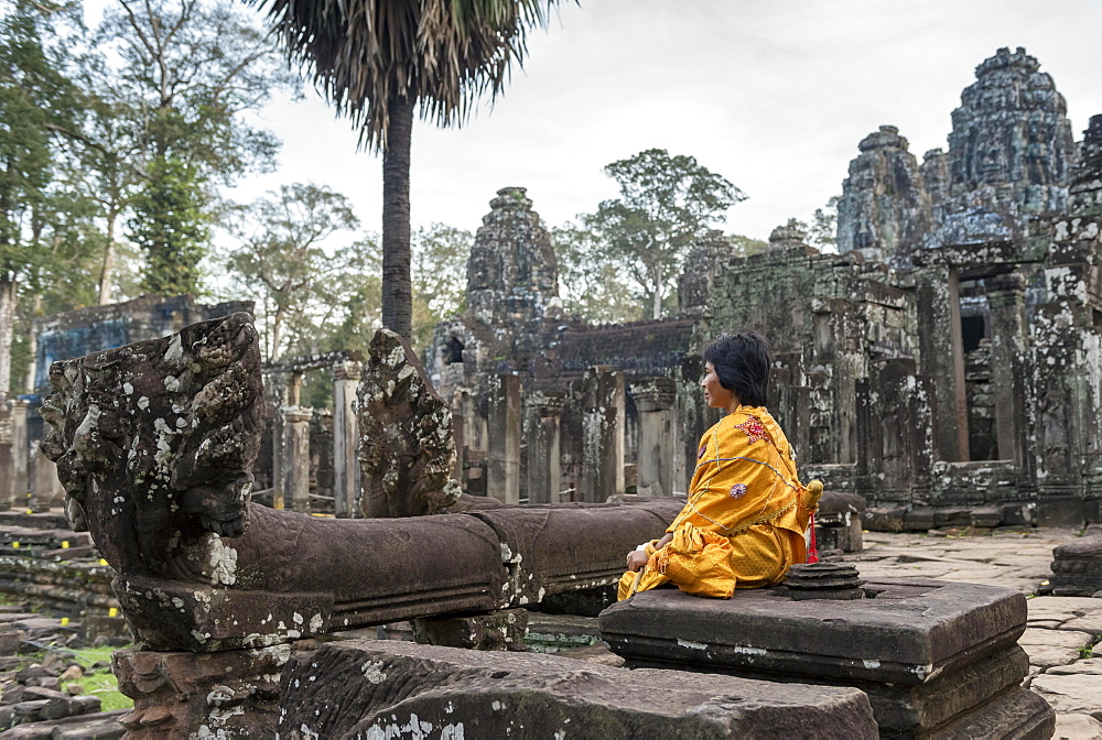 Woman meditates at Bayon Temple, Angkor Thom, Cambodia, Asia