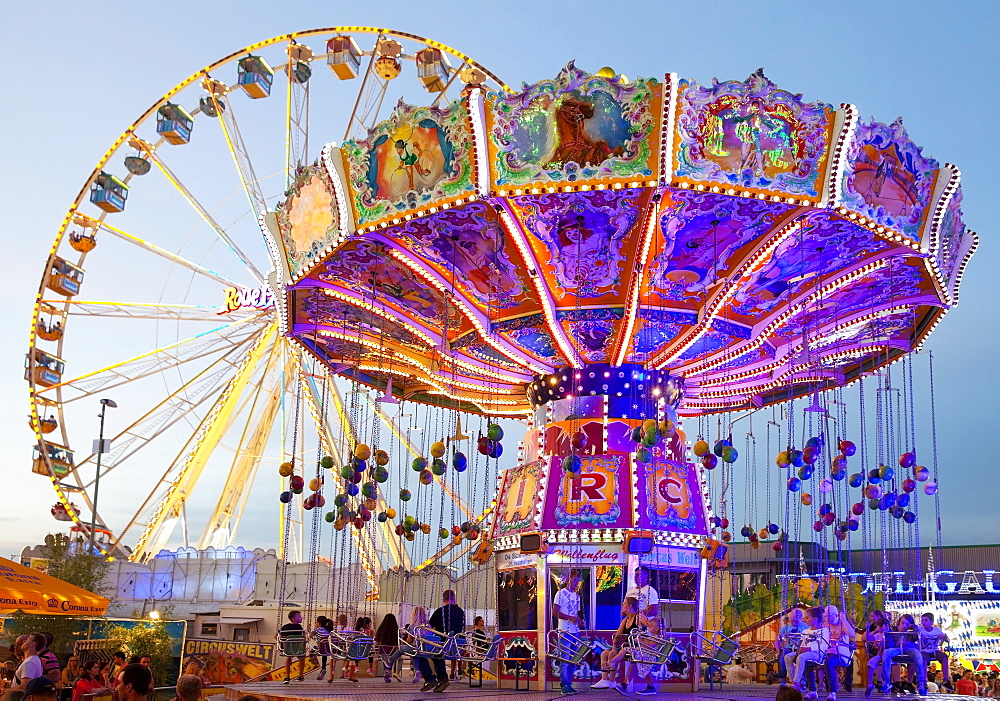 Illuminated swing carousel and Ferris wheel, Cranger Kirmes, the largest folk festival in the Ruhr district, Herne, North Rhine-Westphalia, Germany, Europe