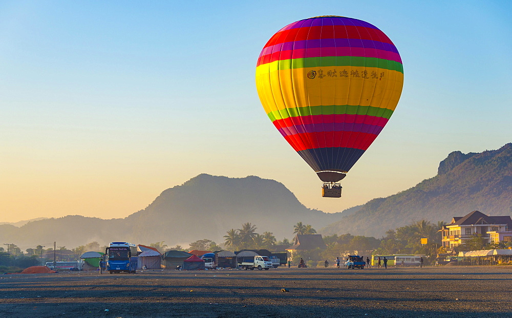 Colorful hot air balloon in the air before landing, back Karst Mountains, Vang Vieng, Vientiane Province, Laos, Asia