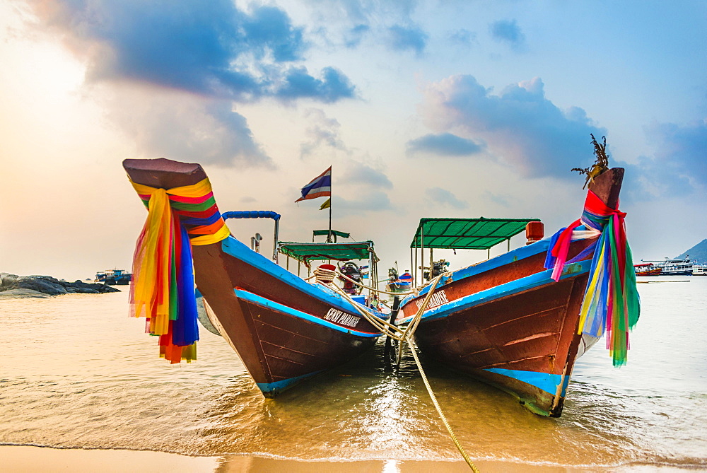 Moored colorful traditional long-tail boats on sandy beach, Ko Pha-ngan, Thailand, Asia