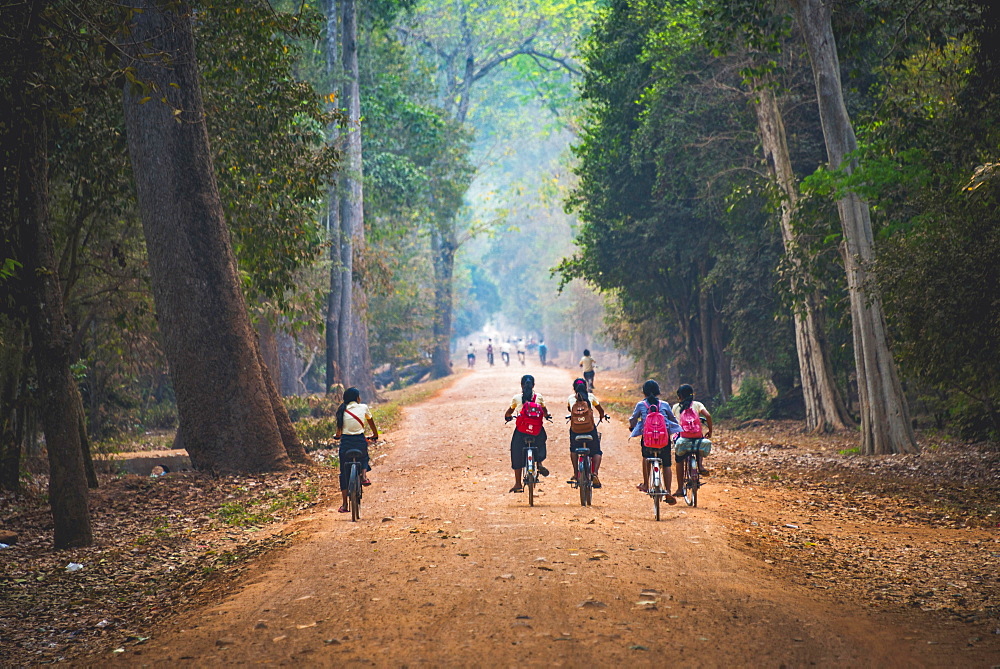 Local children ride bicycles, way to school, Angkor Archaeological Park, Siem Reap Province, Cambodia, Asia