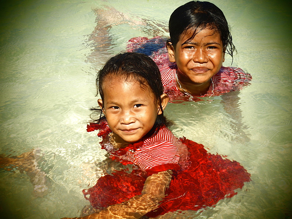 Two girls, 6 years, swimming fully dressed on the beach of Koh Bulong, Thailand, Asia