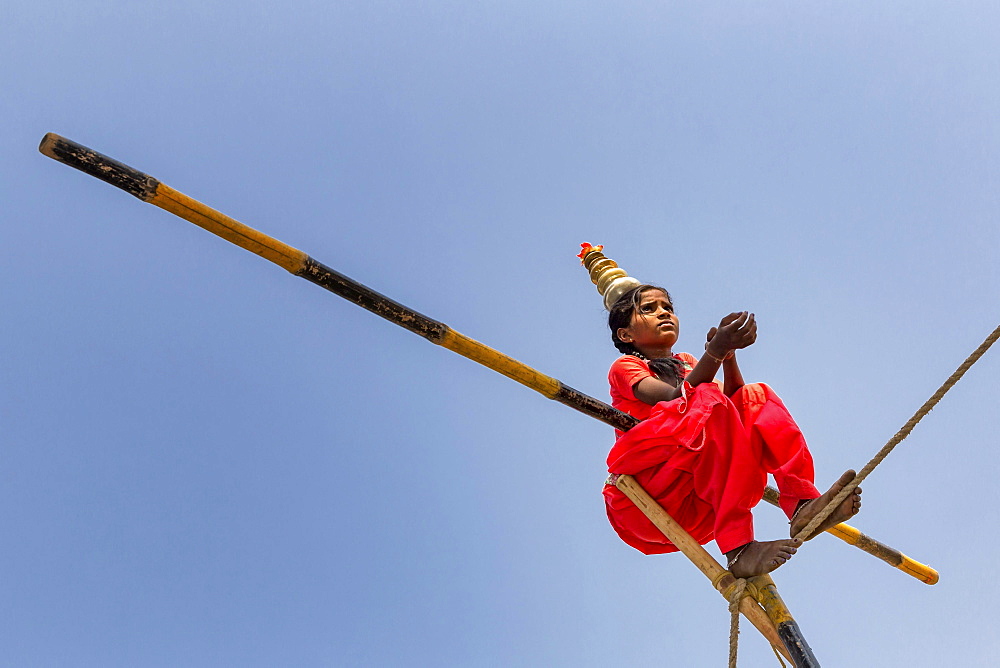 Young girl balancing a on rope, Pushkar, Rajasthan, India, Asia