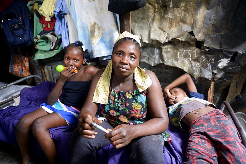 Woman, 40 years, and two children, 8 and 10 years, in barracks, Camp Icare for earthquake refugees, 5 years after the 2010 earthquake, Fort National, Port-au-Prince, Haiti, Central America