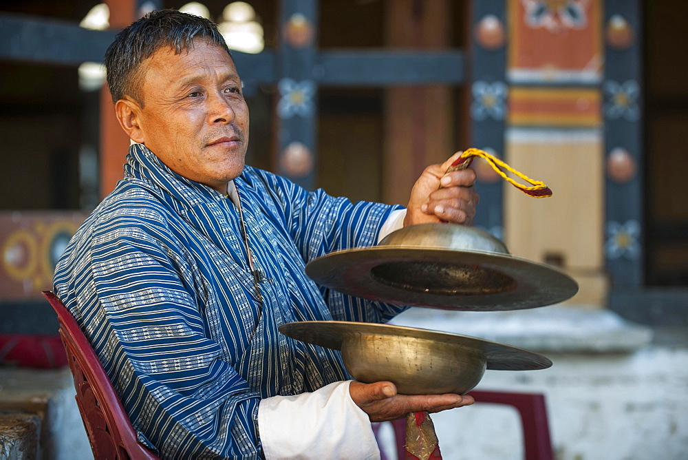 A man with cymbals at a temple festival, Mongar District, Himalayas, Kingdom of Bhutan