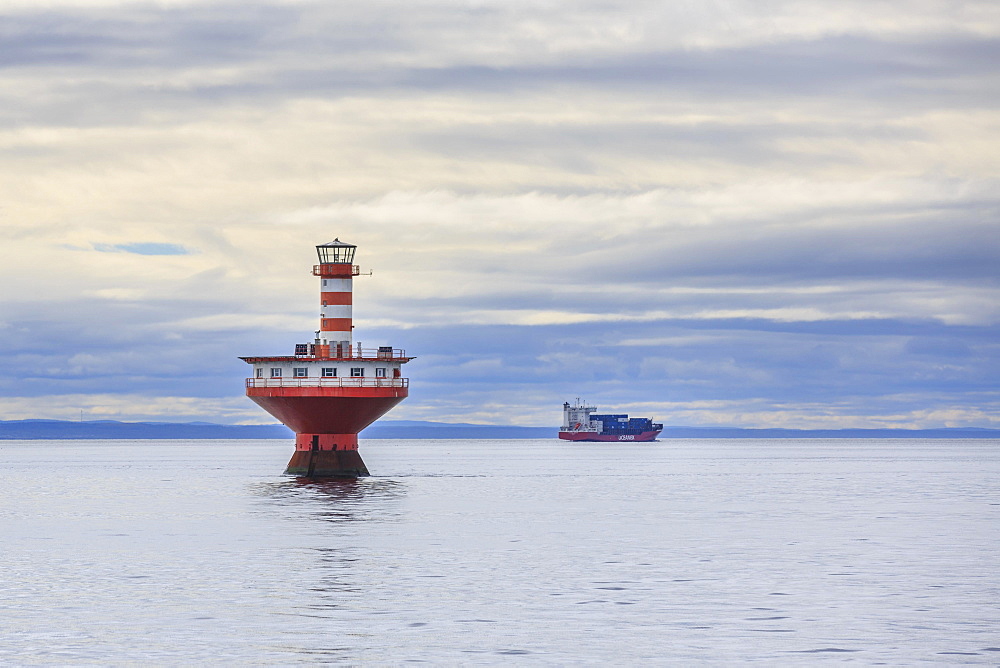 Lighthouse Phare du Haut-Fond Prince in Saint Lawrence River with freighter in the back, Tadoussac, Québec Province, Canada, North America