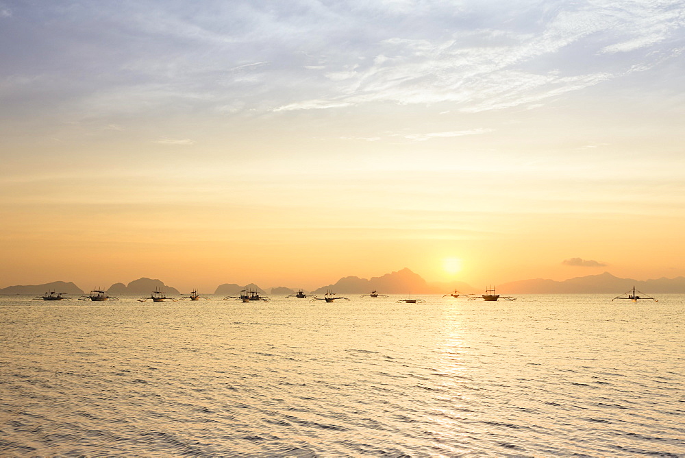 Outrigger canoes at sunset, view from Corong Corong beach near El Nido, Bacuit archipelago, Palawan island, Philippines, Asia