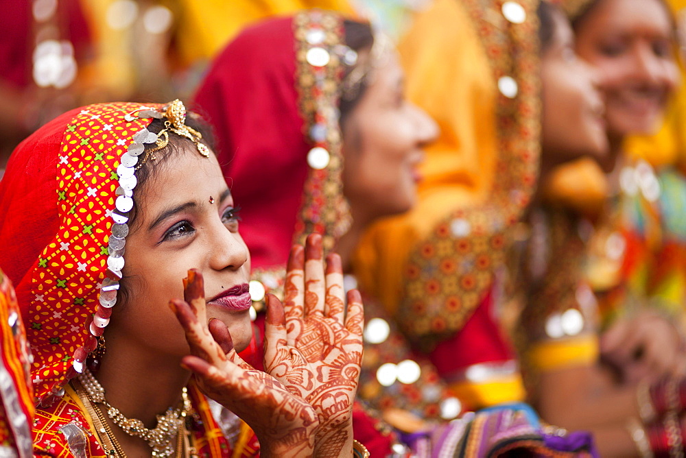 Young women in typical colourful traditional Rajasthani costume and henna painted hands at the camel market and livestock market, Pushkar Mela, Pushkar, Rajasthan, India, Asia