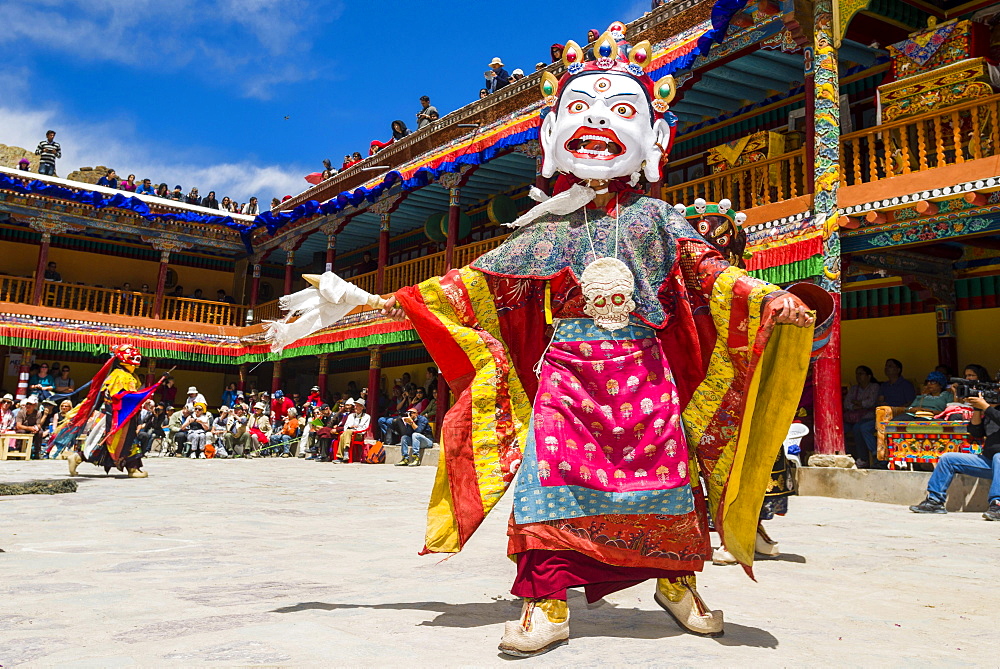 Monks with big wooden masks and colorful costumes are performing ritual dances at Hemis Festival in the courtyard of the monastery, Hemis, Jammu and Kashmir, India, Asia