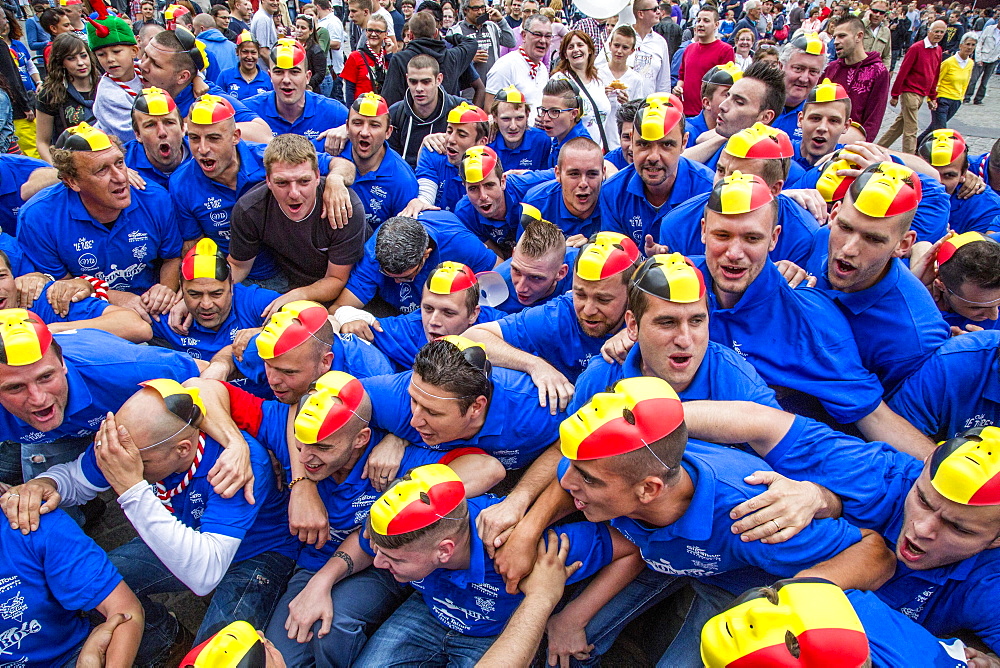 Crowd with the Belgian flag as a mask on their heads, Doudou city festival in Grand Place square, Mons, Belgium, Europe