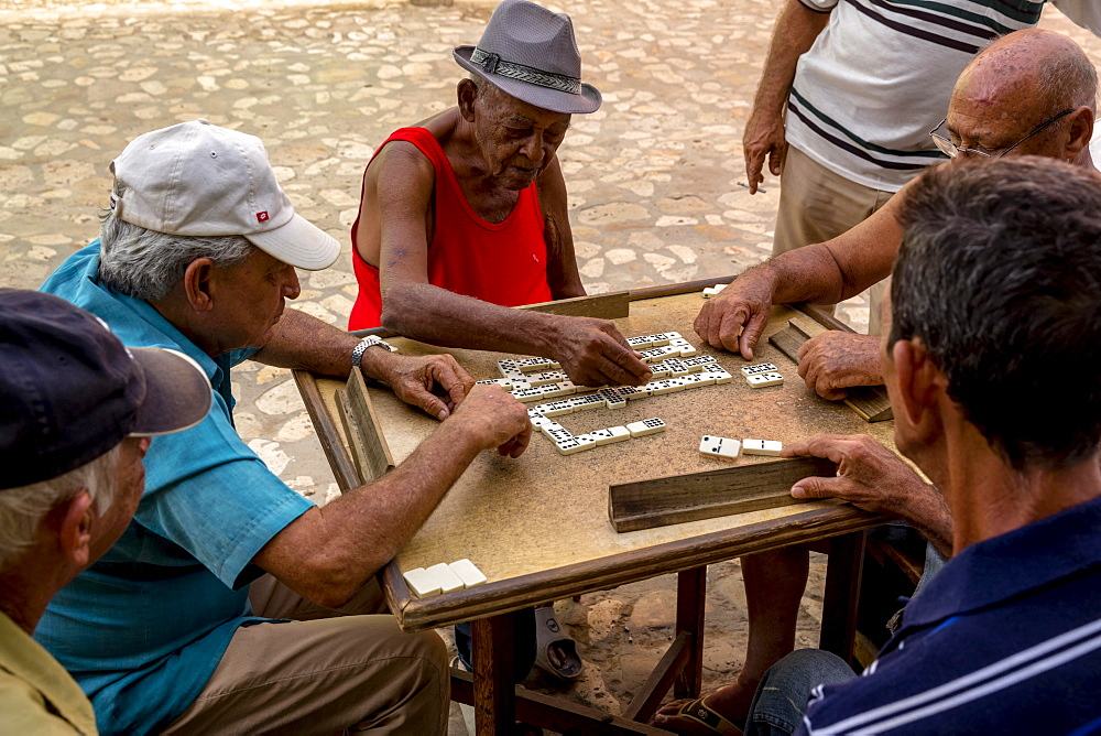 Cuban men playing dominoes at a table outside, old town,Trinidad, Sancti Spiritus Province, Cuba, Central America