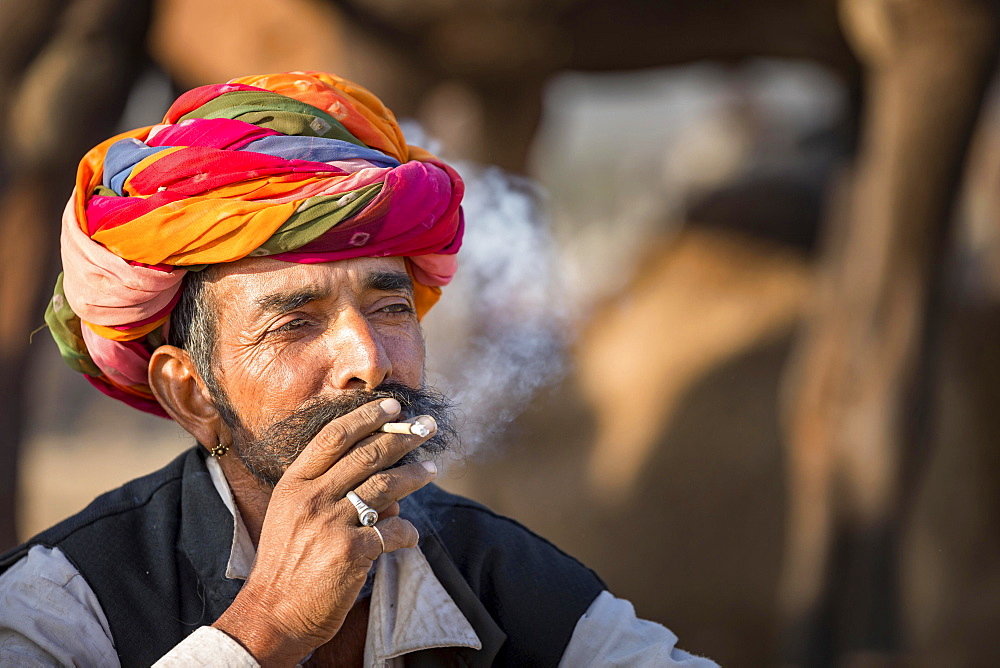 Portrait of Rajasthani man with turban smoking a cigarette, Pushkar, Rajasthan, India, Asia