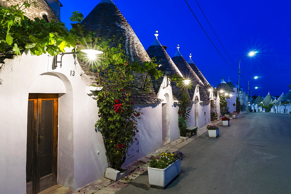 Trulli, traditional round houses, trullo settlement, at dusk, blue hour, Rione Monti district of Alberobello, Valle d'Itria, Trulli Valley, Apulia, Italy, Europe