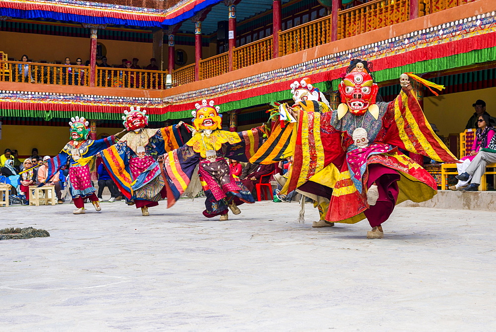 Monks with big wooden masks and colorful costumes are performing ritual dances at Hemis Festival in the courtyard of the monastery, Hemis, Jammu and Kashmir, India, Asia