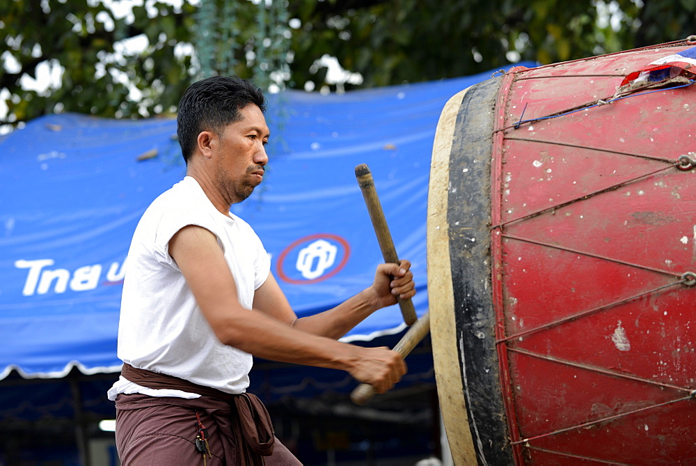 Man drumming outside the Wat Phra Si Rattana Mahathat Temple, Phitsanulok, Northern Thailand, Thailand, Asia