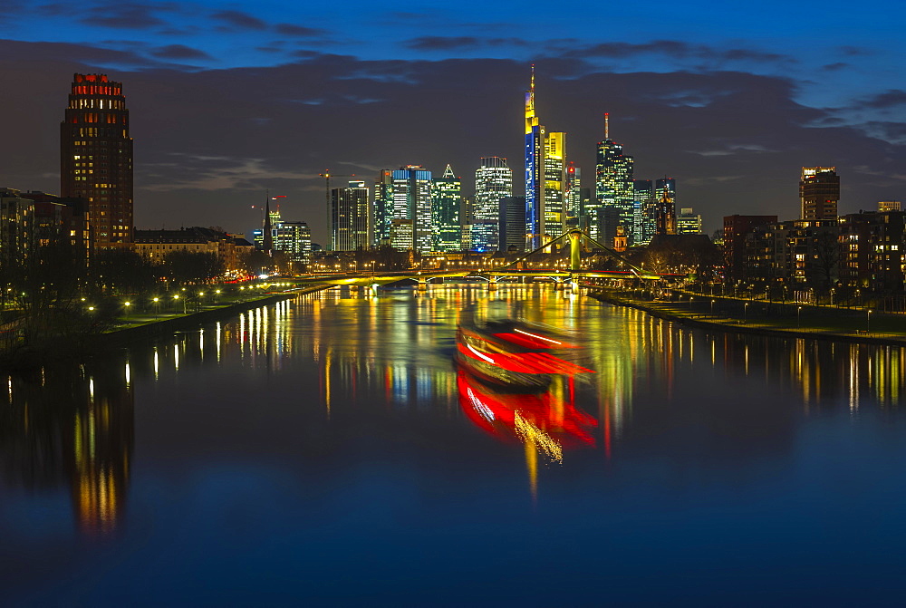 Trail of light from boat in front of skyline, blue hour, Osthafen, Frankfurt am Main, Hesse, Germany, Europe