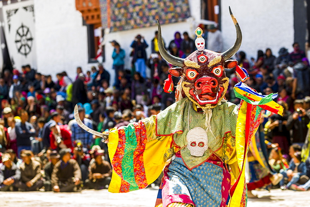 Monks with big wooden masks and colorful costumes are performing ritual dances at Hemis Festival in the courtyard of the monastery, Hemis, Jammu and Kashmir, India, Asia