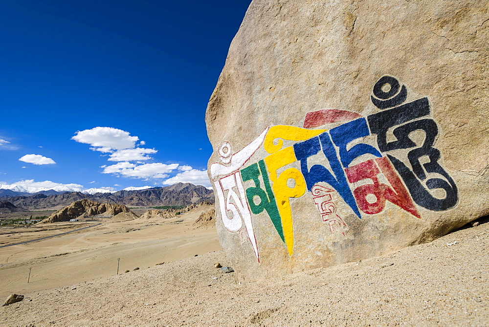 A big Tibetan Mani Stone with the Mantra "Om Mani Padme Hum" colorfully engraved on a hill above the Indus Valley, Shey, Jammu and Kashmir, India, Asia