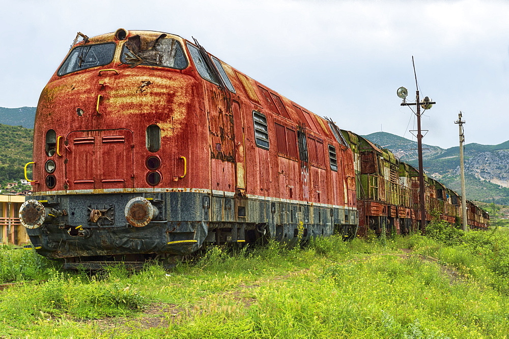 Decayed locomotive and train at former railway station, Prrenjas, Albania, Europe