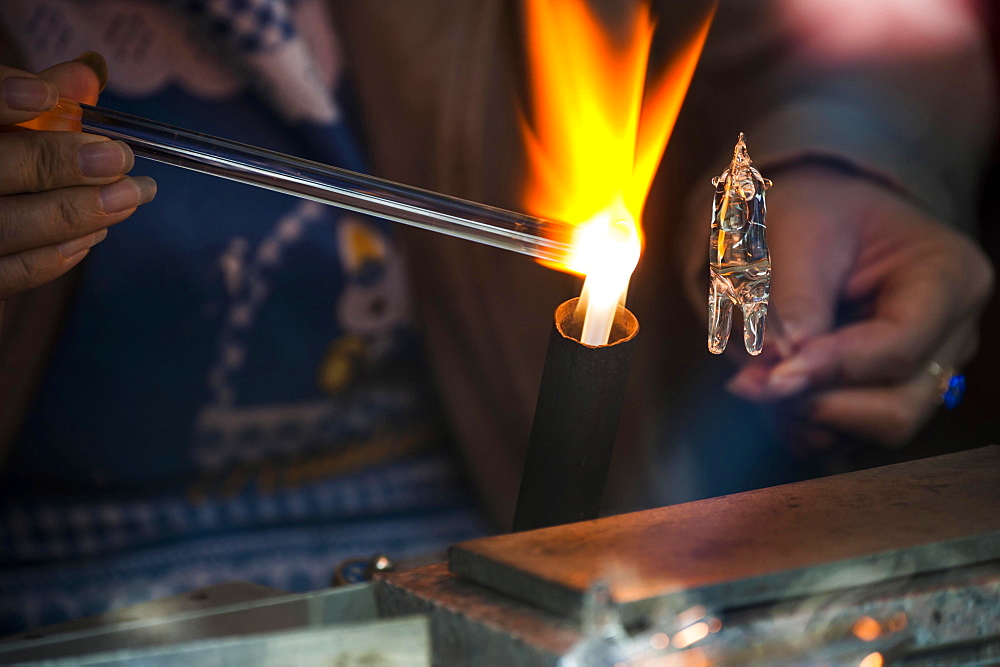 Glassblower working on a glass figure with a flame, Wuzhen, Zhejiang province, China, Asia