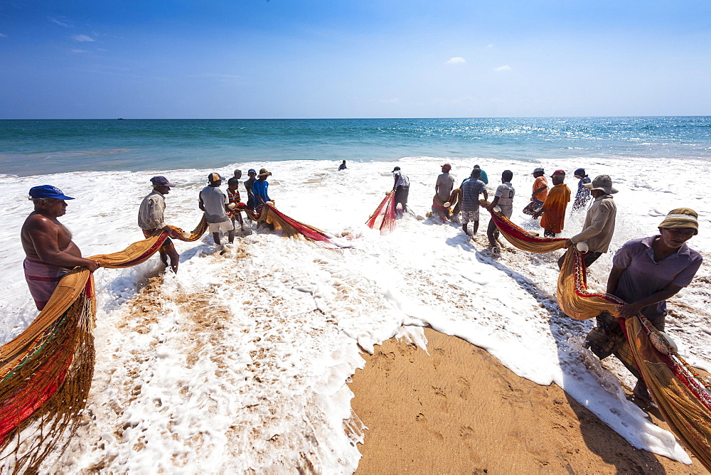 Fishermen, day labourers, hauling in a net on the beach, near Kottegoda, Southern Province, Sri Lanka, Asia