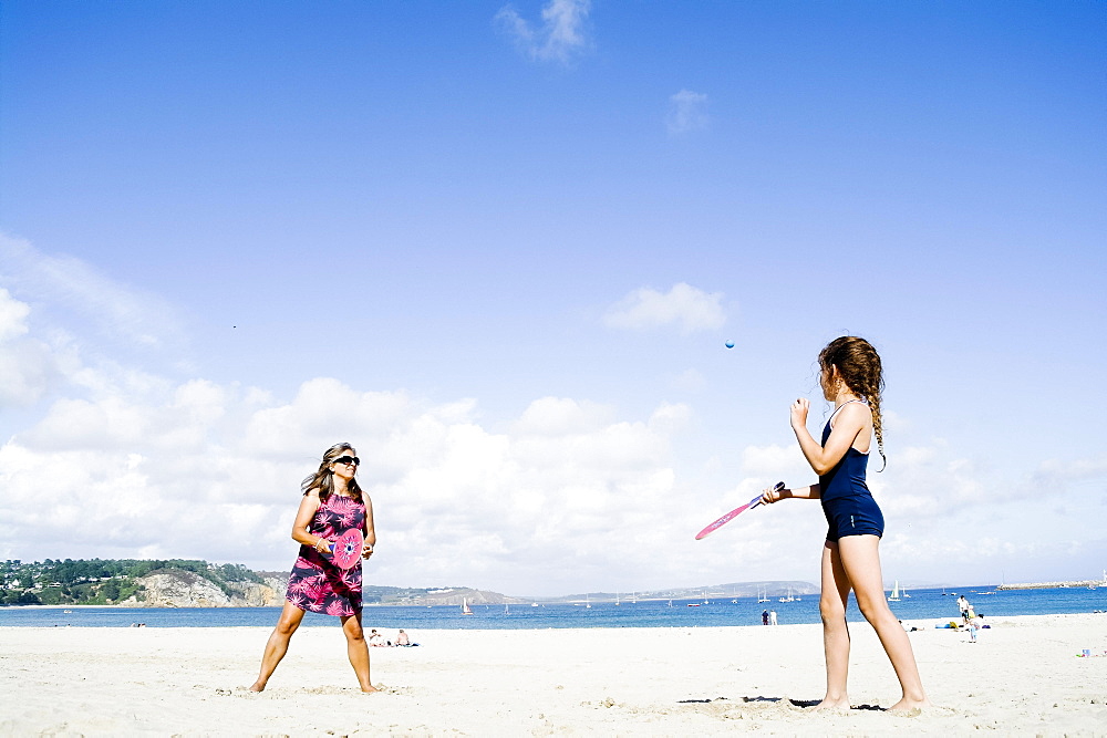 Mother and daughter playing beach bat and ball, Morgat, Brittany, France, Europe