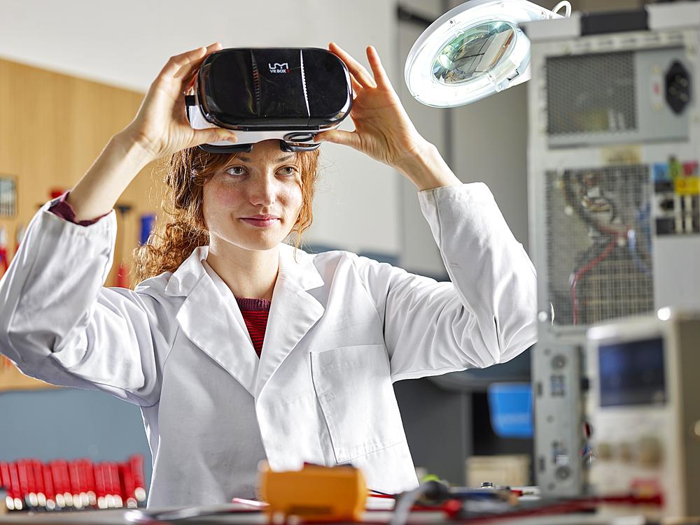 Engineer with white lab coat with VR goggles, Austria, Europe