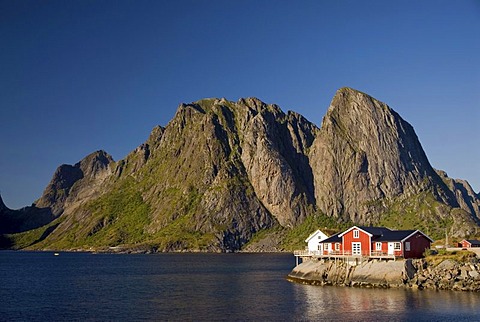 Typical red rorbuer huts, rorbu, at the coast of the Norwegian Sea, mountains at back, Hamnoy, island of Moskenesoy, Moskenesoy, Lofoten archipelago, Nordland, Norway, Europe