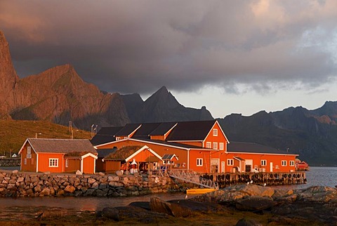 Rorbuer huts, rorbu, in warm morning light, in the tiny village of Sakrisoy, Sakrisoy, mountains behind, island of Moskenesoy, Moskenesoy, Lofoten archipelago, Reine, Nordland, Norway, Europe