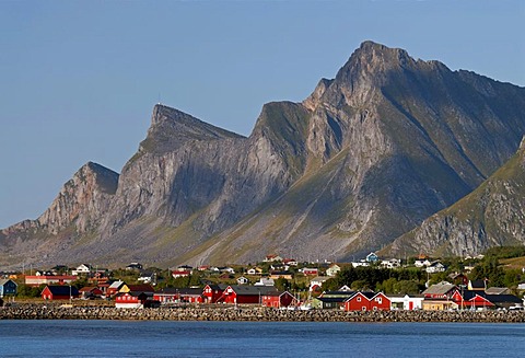 The red houses of Ramberg at the coast of the Norwegian Sea in front of the steep peaks of Flakstadoya, Flakstadoya island, Lofoten archipelago, Nordland, Norway, Europe