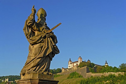 The statue of Saint Kilian on the Alte Mainbruecke, Old Main Bridge with the Festung Marienberg, Marienberg Fortress at back, Wuerzburg, Lower Franconia, Bavaria, Germany, Europe